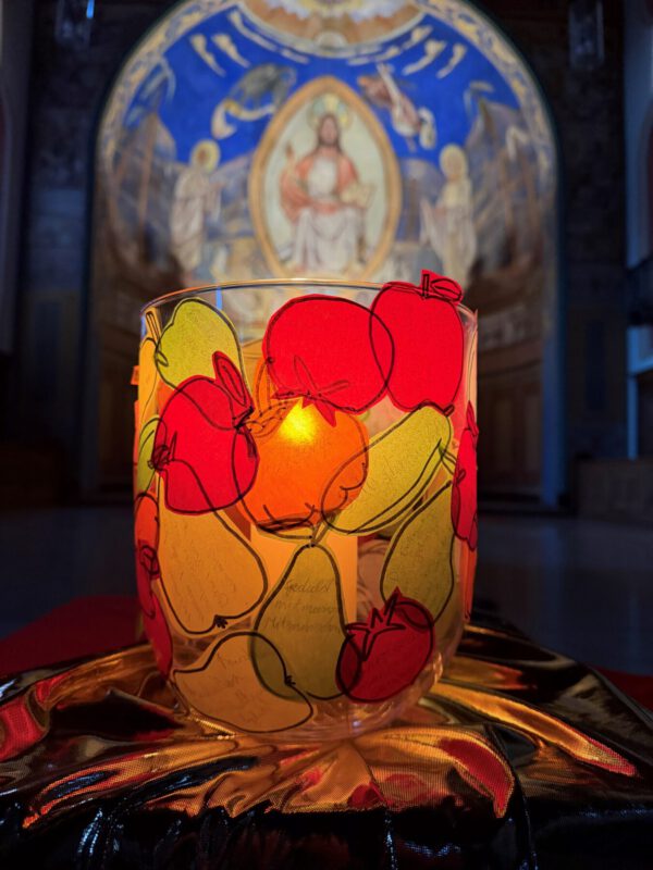 Das bunte Glas mit einer Kerze vor der Apsis von St. Peter und Paul