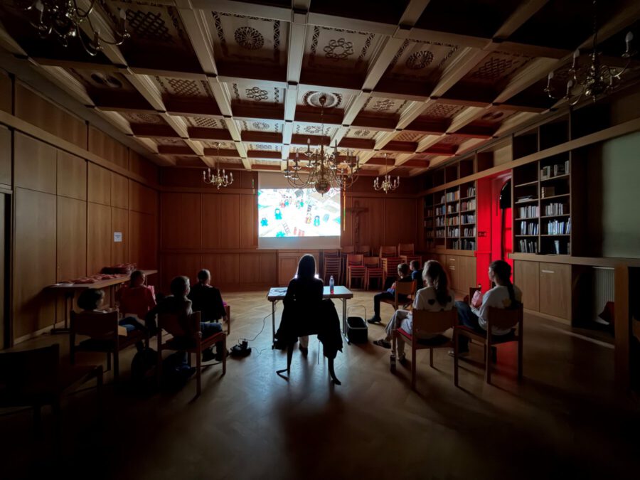Kino bei den Kinderbibeltagen: Kinder schauen einen Film in der abgedunkelten Bibliothek